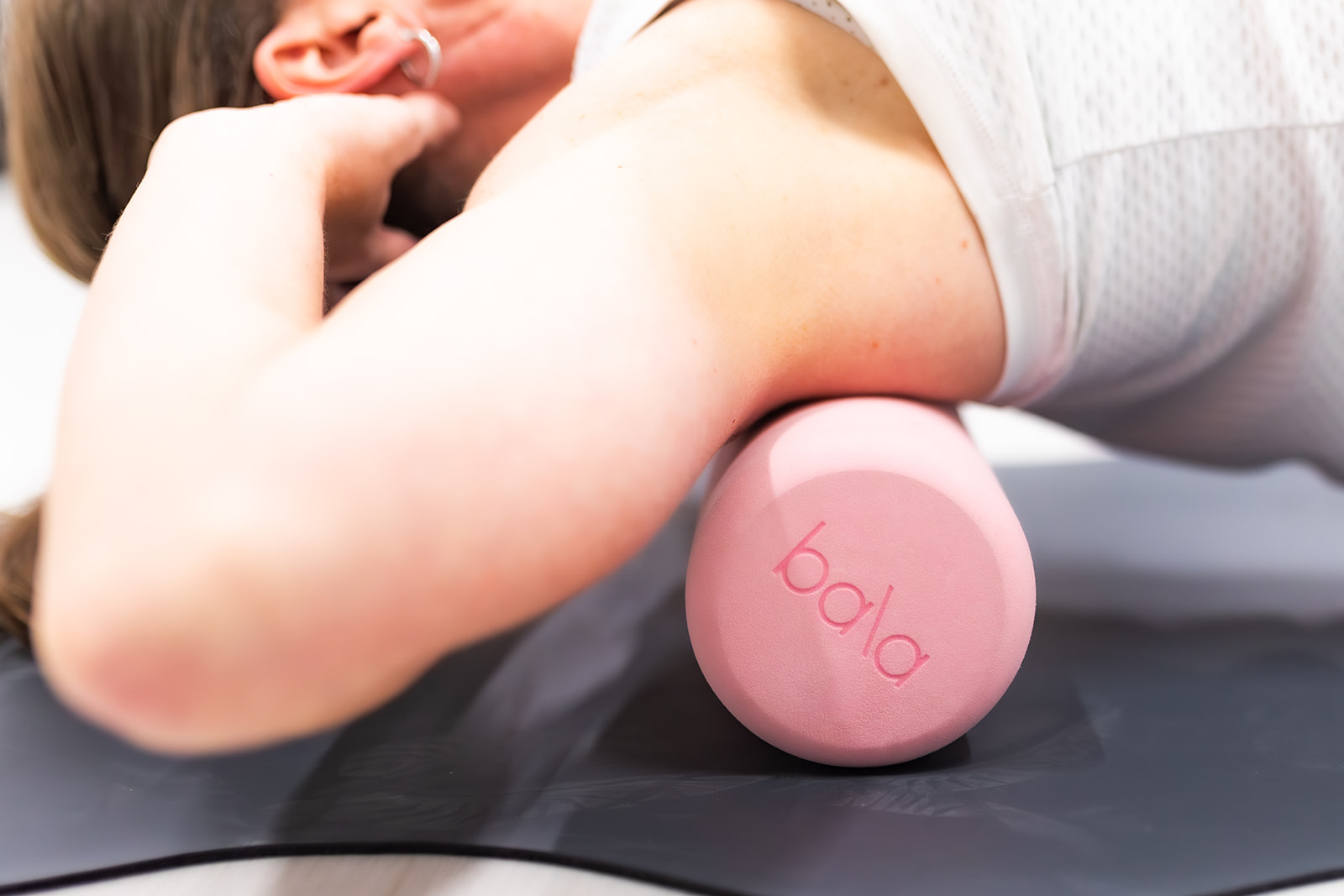 Client rolling out on a blush pink foam roller