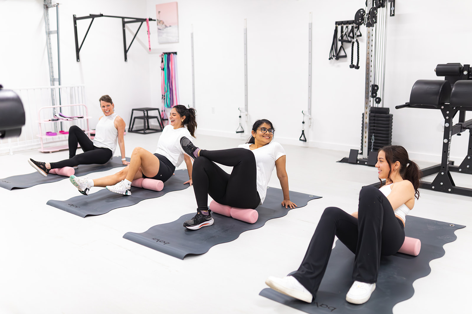 Clients foam rolling on mats during a restorative session