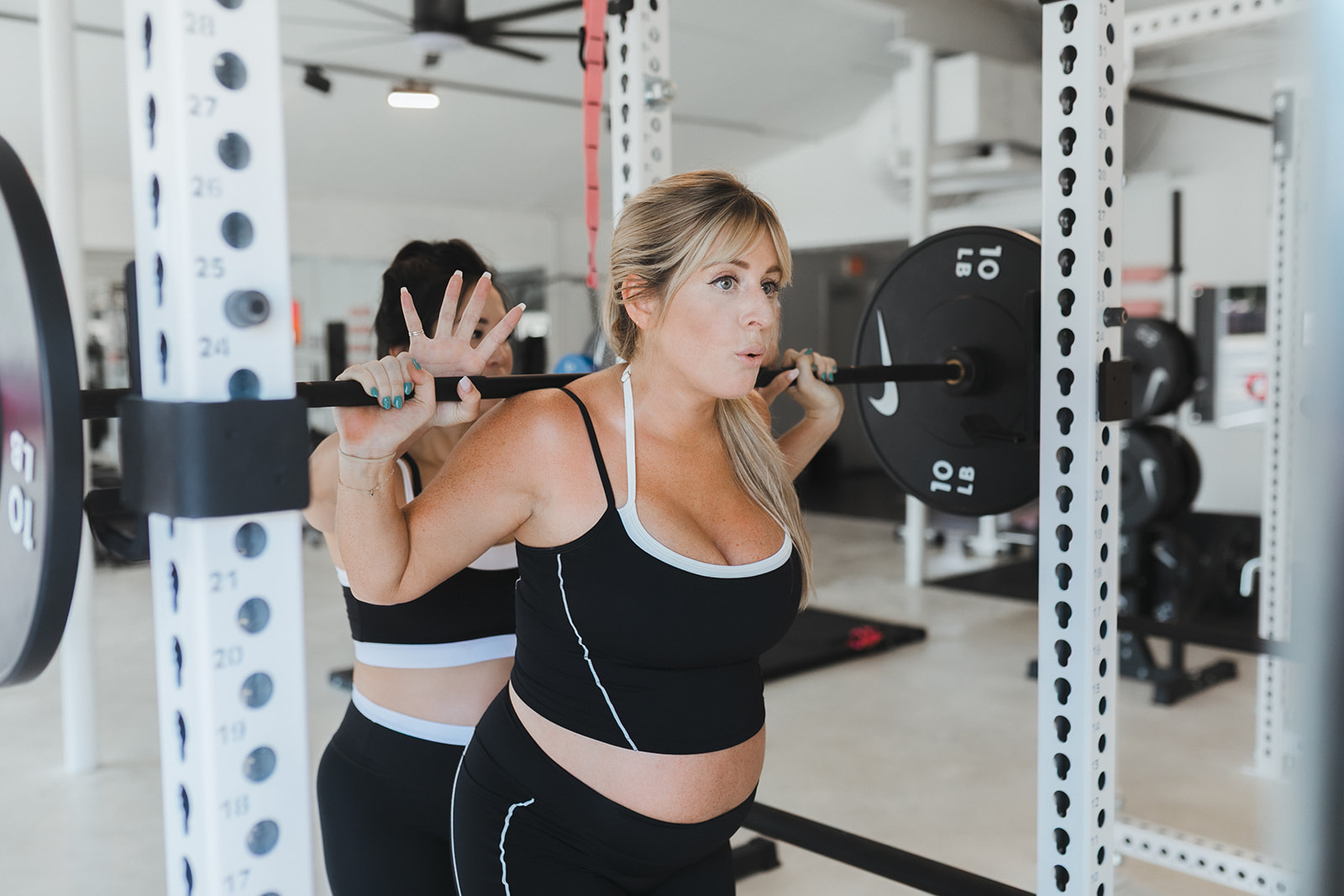 Coach supporting an expectant mother during a lift