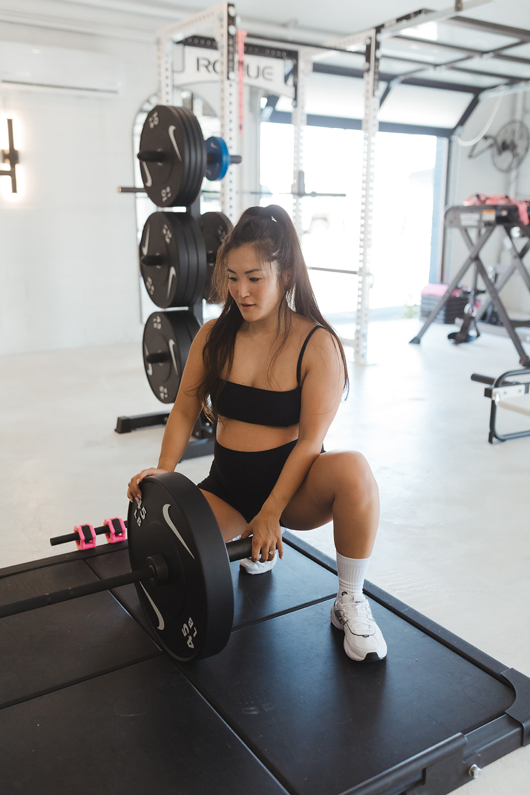 Jessica loading a barbell on the studio lifting platform